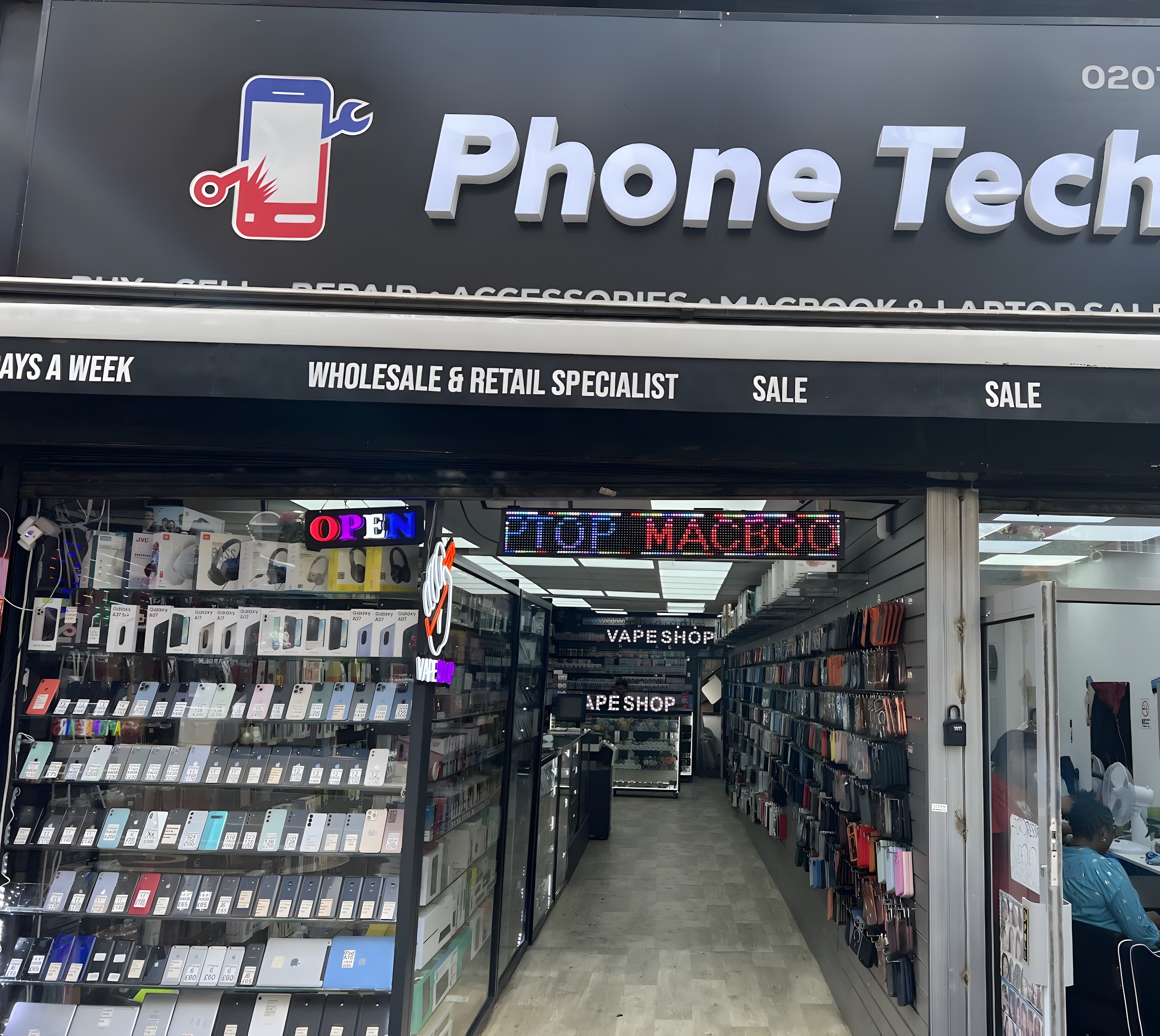 Phone Tech shopfront on Kingsland High Street, Dalston, with phones, cases and accessories on display